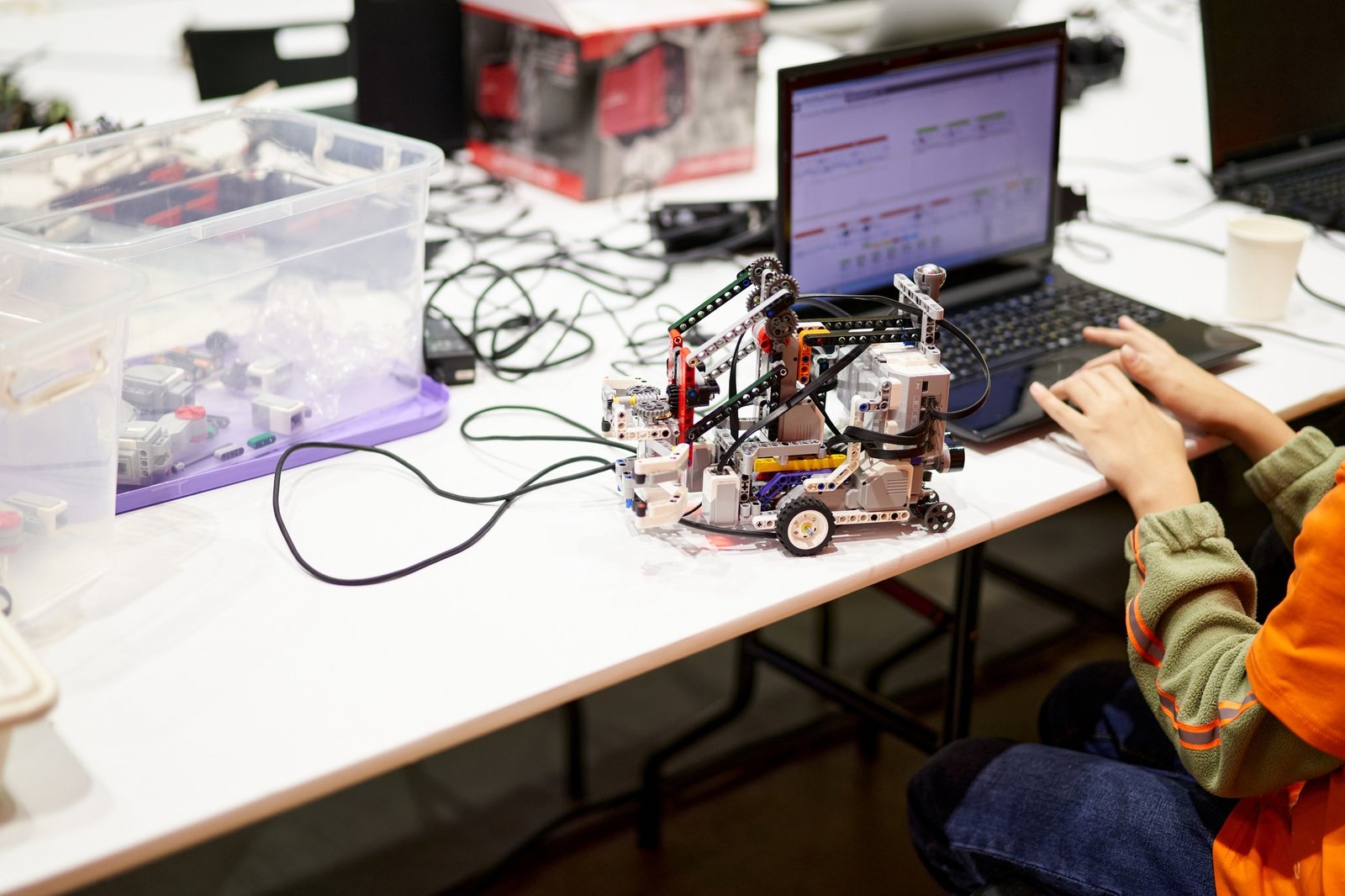 The hands of a child working in a robot creation program.