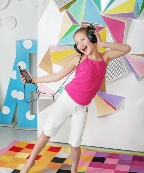 Child girl dances and sings. Listen to music. The concept of music and childhood.